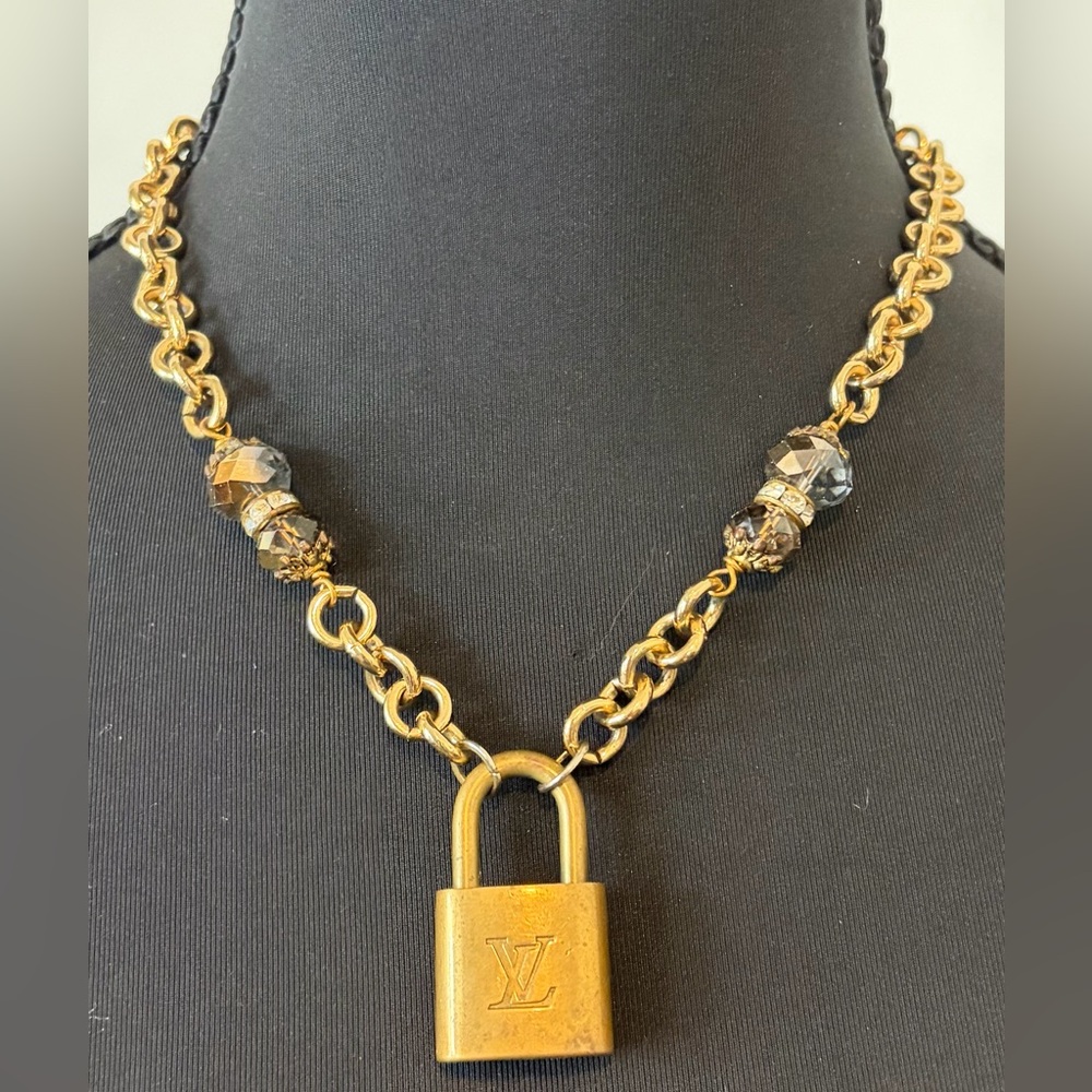 Gold necklace with Louis Vuitton lock and key.